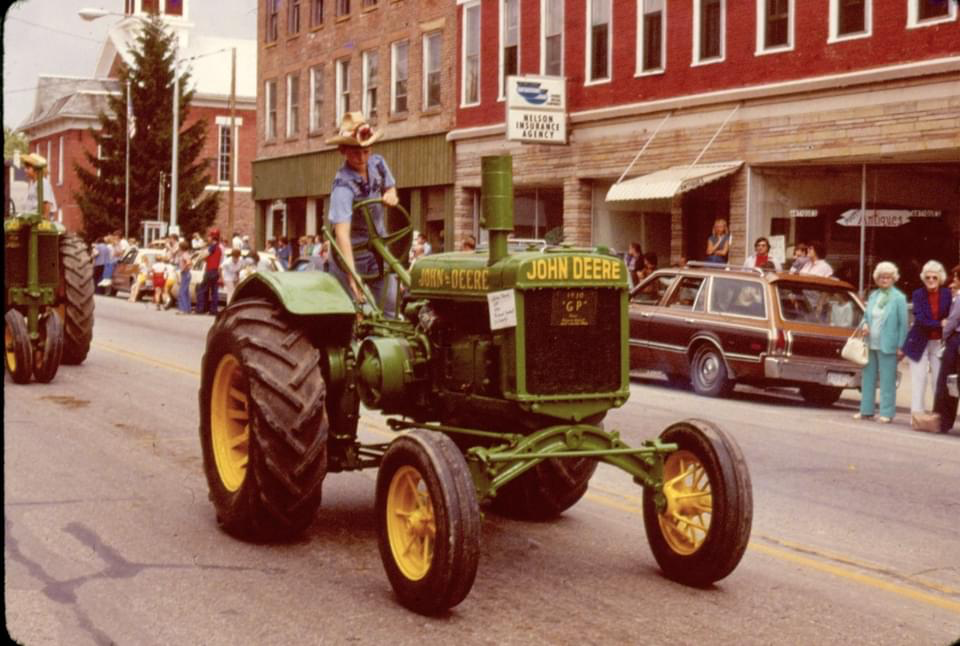 Chad Kimball driving a John Deere tractor in a Labor Day parade in West Liberty
